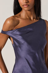 A woman is wearing a sleeveless, satin dress in a rich, dark purple color. The dress features an asymmetrical neckline with one shoulder exposed and the other covered, creating a stylish off-shoulder design. The fabric has a smooth, shiny finish, giving it an elegant and sophisticated appearance.