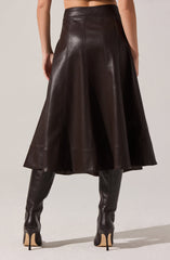 The image shows a person wearing a high-waisted, dark brown leather skirt that falls below the knees with a slight flare. They are also wearing matching dark brown leather thigh-high boots with high stiletto heels. The outfit has a sleek and polished appearance, emphasizing the texture and shine of the leather materials.