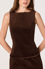 A woman is wearing a sleeveless, fitted brown dress made of a textured fabric. The dress has a round neckline and a thin matching belt at the waist.