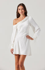 A woman is wearing a white satin mini dress with an asymmetrical neckline. One shoulder is off-the-shoulder, while the other is covered by a long, draped sleeve. The sleeve features feathered embellishments at the cuff. The dress has a fitted bodice and a slightly flared skirt.