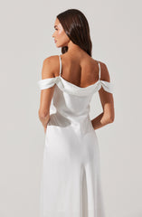 A woman is wearing a white satin jumpsuit with off-the-shoulder sleeves that are draped and gathered. The jumpsuit features thin shoulder straps and has a smooth, flowing appearance from the fitted waist down to wide-leg trousers.