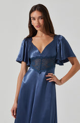 A woman is wearing a deep blue satin dress with a V-neckline. The dress features short, puffed sleeves with a ruffled, shiny satin finish. The bodice has pleated detailing and a wide lace band at the waist, adding texture and contrast. The skirt is smooth, flowing, and made of satin fabric.