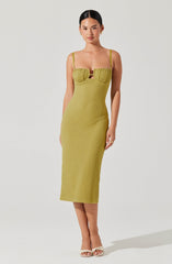 A woman is wearing a lime green, textured, fitted midi dress with spaghetti straps. The dress features a gathered bust area with a small cutout in the center. She is also wearing open-toed, beige high-heeled sandals and small earrings.