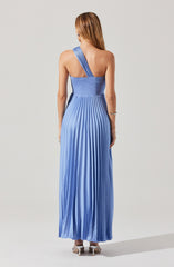 The dress is a floor-length gown made of shiny, pleated fabric in a gradient of blue shades. It features a one-shoulder design with a wide strap over the left shoulder, leaving the right shoulder bare. The fitted bodice transitions into a flowing, pleated skirt that reaches the floor.