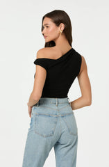 A woman is wearing an off-the-shoulder black top with a draped neckline and short sleeves that are rolled up. She has paired it with high-waisted light blue jeans that have a classic five-pocket design. She accessorized with gold hoop earrings.
