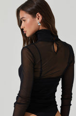 A woman is wearing a sheer black long-sleeve top with a high neckline. The top has a keyhole cutout at the back near the neck. She also has a large, silver, spiral-shaped earring.