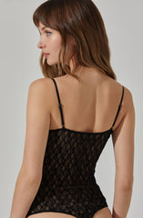 A woman is wearing a black lace camisole with thin, adjustable spaghetti straps. The camisole features a floral lace pattern and fits snugly to her body.
