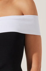 A person wearing a strapless top with a wide white band at the top and black clothing below.