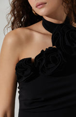 A woman is wearing a black strapless dress with decorative fabric flowers on the bodice and a matching black choker with large fabric flowers.