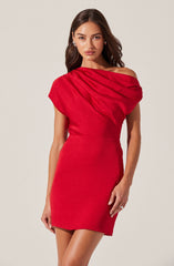 A woman is wearing a fitted red dress with an asymmetrical neckline. The dress has a draped detail on the shoulder and a smooth, streamlined skirt.