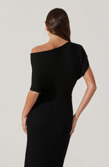 A woman is wearing a fitted, black ribbed dress with a scooped neckline. The dress features a textured, horizontal rib pattern on the top and a vertical rib pattern on the skirt. The fabric appears knit and form-fitting.