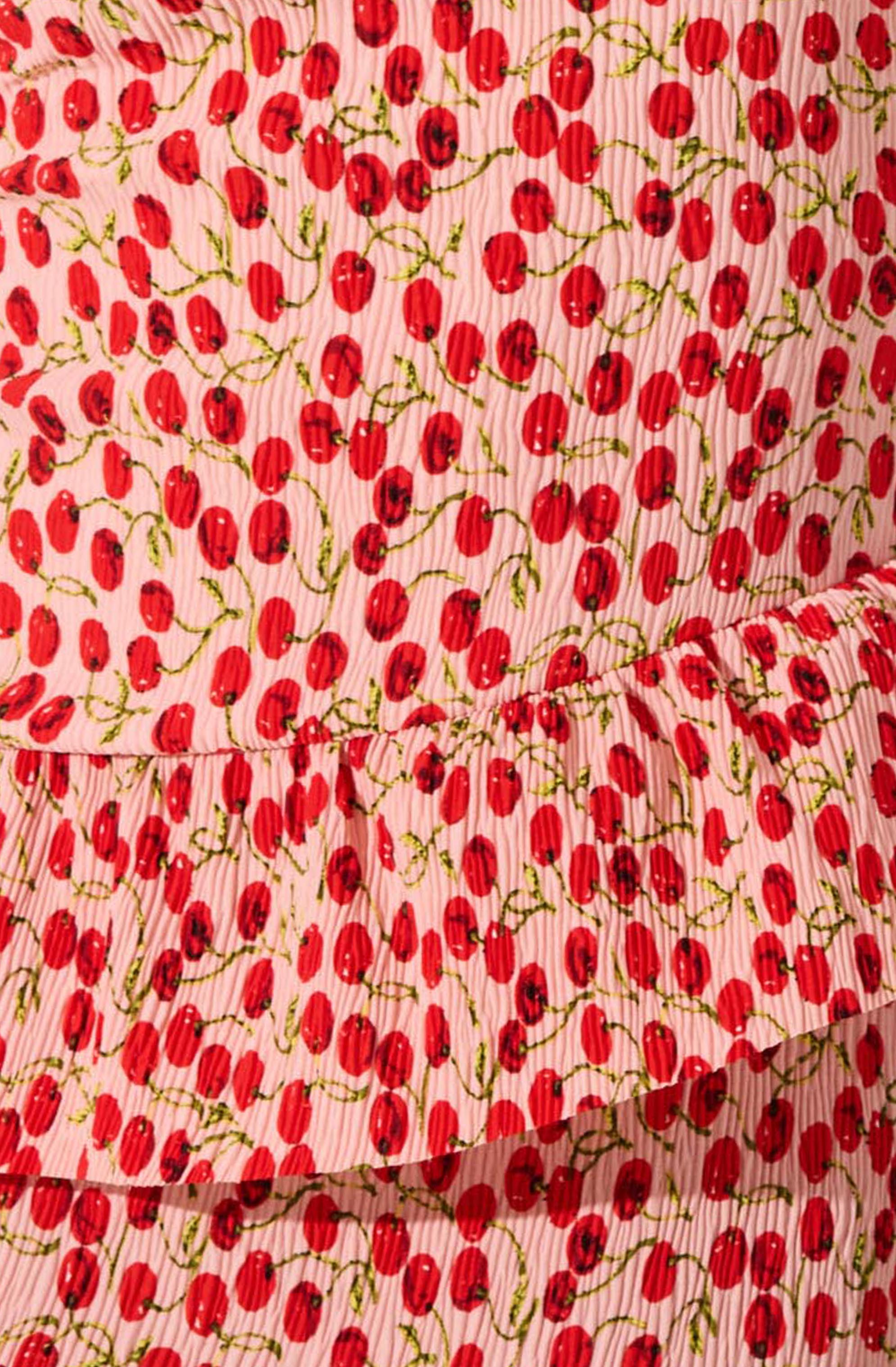 The fabric features a pattern of red cherries with green stems on a pink and white vertical striped background. The material appears to be lightweight and slightly textured.