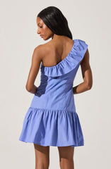 A woman is wearing a sleeveless, one-shoulder dress in a light blue color. The dress features a ruffled detail along the single shoulder strap and a gathered, ruffled hemline at the bottom.