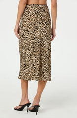 A woman is wearing a pair of high-waisted, midi-length pants with a leopard print pattern in shades of tan, black, and brown. The pants are loose-fitting and flowy, with a wide waistband. She is also wearing black high-heeled sandals with thin straps.