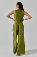 A woman is wearing a sleeveless, olive-green pantsuit with a textured, pleated fabric. The top has a high neckline and a loose fit, while the wide-leg pants feature the same textured, pleated design throughout.